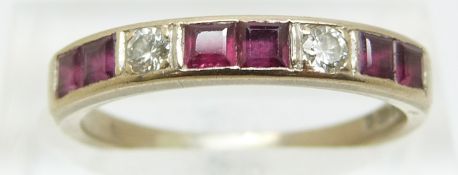 An 18ct gold ring set with square cut rubies and two round cut diamonds, size O