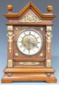 Architectural oak cased mantel clock with ivory coloured Roman chapter ring, brass decoration,