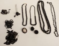 A collection of jet jewellery including faceted beaded necklaces, a brooch set with a cameo by B H