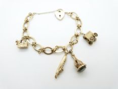 A 9ct gold charm bracelet with four 9ct gold charms including a seal set with bloodstone and a cat