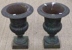 A pair of late 19th/20th century cast iron pedestal campana urns/jardinieres with impressed