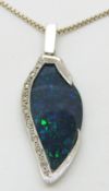 An 18ct white gold pendant set with a black opal of approximately 3.24ct set with a line of diamonds