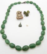A silver brooch set with serpentine, a Buddha, a jadeite charm and an aventurine necklace