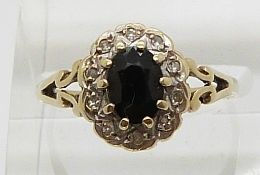 A 9ct gold ring set with an oval cut sapphire and diamonds (size P)