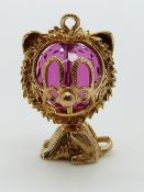 A 9ct gold charm/ pendant in the form of a cat with a pink paste bead to the head, 7.5g