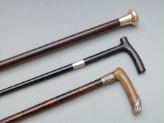 Three silver and white metal mounted walking canes, London 1924 the other two unmarked, one having