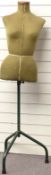 A vintage tailor's dummy raised on a green metal stand, height 144cm