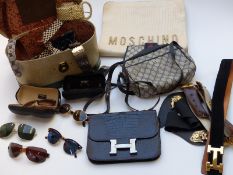 A collection of handbags including a large clutch bag with applied Moschino, designer leather belts,
