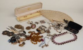 A collection of costume jewellery including brooches, filigree brooch, glasses, pocket watch face,