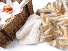 A large wicker basket with leather hinged lid containing a large quantity of linen, lace and