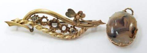 A yellow metal pendant set with an agate cabochon and a yellow metal brooch set with two rose cut