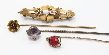 A 9ct gold brooch, silver stick pin set with an amethyst and two other stick pins