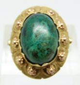 A 14k gold ring set with an azurite cabochon, with textured detail to the setting, marked W9H,  size