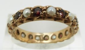 A 9ct gold eternity ring set with pearls and garnets (size O)