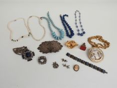 A collection of jewellery to include a white metal buckle, glass beads, ceramic beads, Les Bernard