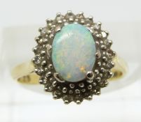 An 18ct gold ring set with an opal and diamonds (size K/L)