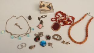 A collection of jewellery including silver locket, brooch, silver thimble, agate necklace, butterfly
