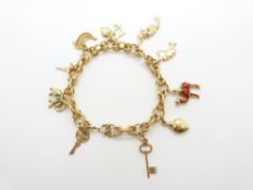 An 18ct gold bracelet with ten 18ct gold charms including an enamel camel and elephant by Fabor,