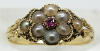 Victorian ring set with a ruby surrounded by seed pearls, with glass compartment verso (size J)