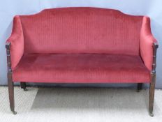 Edwardian red upholstered sofa with turned front columns, terminating in brass castors