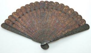 A 19thC Chinese tortoiseshell brise fan finely carved with a central Fo Dog scene, further court