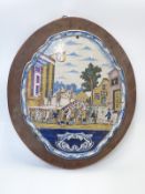 19thC large continental Delft plaque decorated with a crowd watching a play, H58cm, W48cm