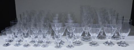 A suite of 53 clear glass drinking glasses all raised on hexagonal bases, largest 15cm tall