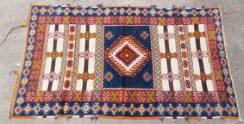 Blue and red ground handmade wool rug with geometric design, 174x106cm