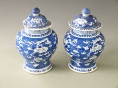 A pair of 18th/19thC Chinese covered prunus vases with four character marks to base, H 27cm