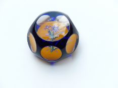 Peter McDougall blue flash overlaid faceted glass paperweight with multi-coloured flowers on an