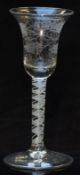An 18thC clear glass drinking glass with engraved bell shaped bowl and white twist decoration to the