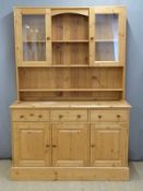 Pine dresser with shelves franked by two glazed cupboard to top, the base fitted three drawers above