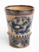 A 19thC salt glazed beaker with plated mounts, decorated with birds and chicks in nests, possibly