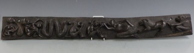 An African carved wooden panel decorated with figures and animals, length 92cm