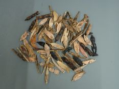 A collection of carved bone tribal items, fish lures, pendants etc