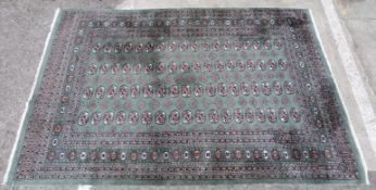 Green ground rug with repeating central design and borders, 265x185cm