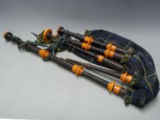 R G Hardie of Glasgow Highland bagpipes with Catalin-mounted turned hardwood drones, the leather bag