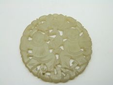 A circular carved jade pendant with pierced figural decoration, diameter 5.8cm