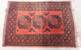 Orange ground handmade wool rug with three central guls, 125x87cm
