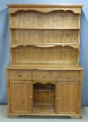 Pine dresser with plate rack top, the base having three drawers above two cupboards flanking central