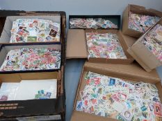 A tray containing a substantial quantity of loose all world stamps in tins, packets etc