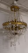A gilt metal and cut glass chandelier originally removed from a Cheltenham hotel and latterly hung