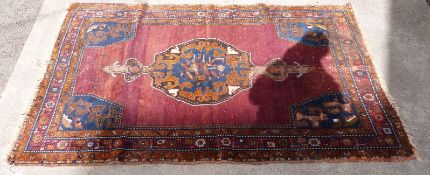 Red and blue ground rug with central likley Middle Eastern motif and repeating borders, 210x137cm