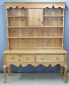 Pine dresser with plate rack and central cupboard to top, the base fitted two drawers, raised on