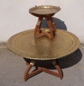 A large Eastern brass portable table with embossed detail on collapsible base together with a