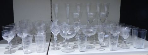 Sixty clear glass drinking glasses including six champagne flutes, sets of wine glasses, beakers