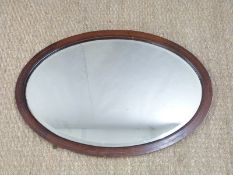 Inlaid mahogany oval bevelled glass mirror, maximum overall diameter 75cm