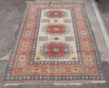 Cream ground handmade wool rug with three central guls and repeating borders, 302x215cm