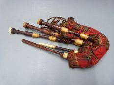 A set of half size Highland bagpipes with ivory effect fittings and rosewood effect drones, the