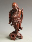 A carved Chinese hardwood figure of an elder with bone teeth and eyes, 30cm